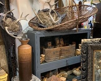 Composite steer skull, turned wood vase, large table centerpiece harvest basket, 4 antler filled horn o plenty in various sizes with rope for hanging or horizontal display, primitive stool, working mid century seated Buddha lamp, hand carved owls
