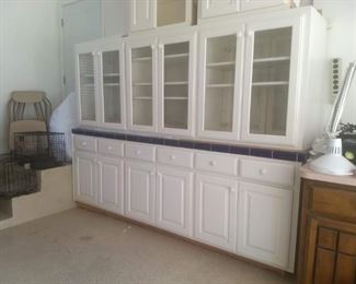 Upper and Lower Beautiful  Kitchen Cabinets that open on both sides -- can be set up as a room divider.  All drawers open very smoothly.  Small Pet Kennel/Carriers, Folding Chairs, another Cabinet for sale to the right - partially shown, and 2 more little cabinet on top.