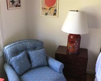 Armchair, side table with 3 drawers, lamp, and wood prints