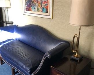 Leather single cushion couch, Leroy Neiman signed/numbered lithograph, 3-drawer side table with brass "horn" lamp