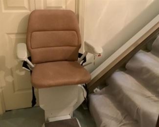Stairlift with railings and remote control by Stannah.