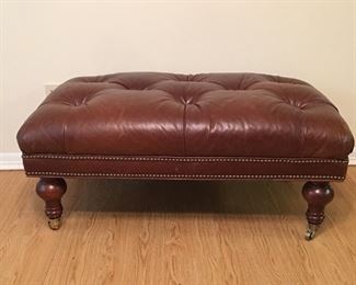 Tufted ottoman on rollers. Dimensions are 42 inches wide by 25 inches deep by 18 inches tall. 