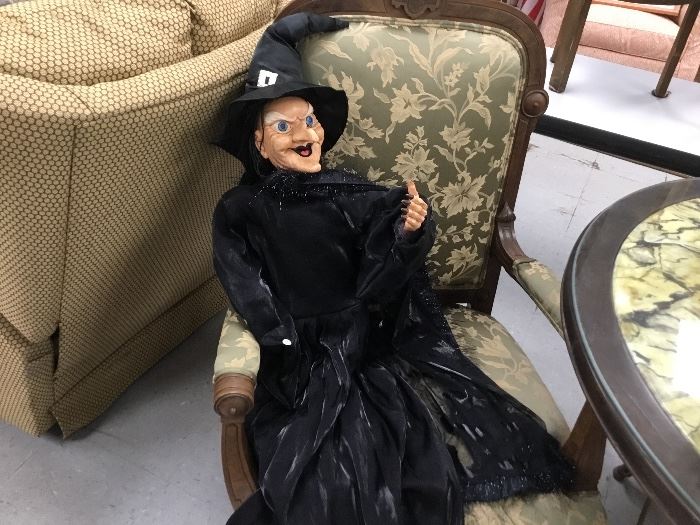 A ghoulish witch seated in a wonderful reproduction arm chair