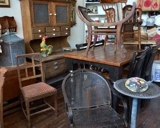 Primitive hoosier-needs some love. to the left of hoosier is a barley twist gate leg table with a copper still on top.
Newer black base table with four chairs.