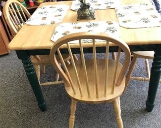 Oak table with green painted legs and matching chairs.