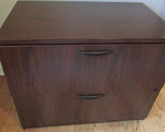 Rosewood laminate file cabinet. Front corner is chipped. H29”, W 70”, D 34” $40