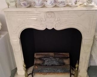 Heavy faux fireplace; some of many cups and saucers