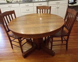 Antique round oak table with one leaf & chairs