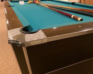 Lot 3484. $750.00.. 8' Regulation Pool Table, Includes Pool Cues, Racks, Brush, Cue Storage Rack & Set of Billiard Balls.  1950's style pool hall table w/nostalgic look. Will need to be professionally moved. Bumper cushions. 96" L x 57" W