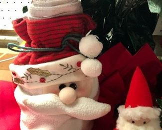 Lot 3541.  $60.00 Merry Christmas Tree Skirt (46"dia), Faux Pointsettia (20"h), Santa bag with Christmas Tea Towels, 2 plush felted Santas (real cute), 1 quilted Santa (Overly-Raker), 1 straw hat snowman with cute buttons, 1 Santa pillow, ceramic tree (good shape, one missing berry and small chip), Cute snow house, 1 Wonderful World of Rambling Ted Figurine (OOOOPs) 1999. 