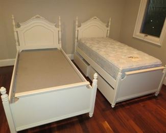 TRUNDLE BED ON LEFT WITHOUT MATTRESS.  BED WITH DRAWERS ON THE RIGHT.