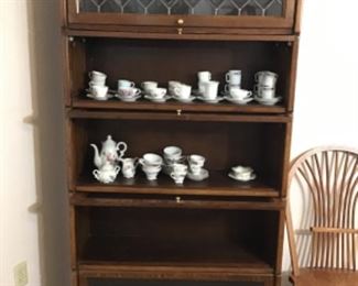 Barrister bookcase, inside a collection of demitasse cups and saucers.