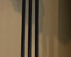 One of two slender black and gold tone lamps