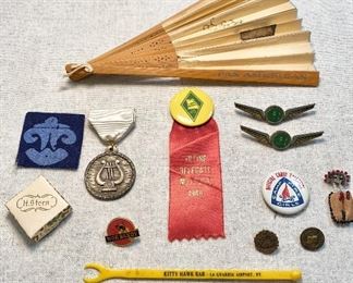 Top-Pan American airlines fan, Middle row-2 "Ozark Airlines" wing pins, Farm Bureau "1949" voting delegate ribbon/pin, 1987-88 Friendship Circle music medallion. Bottom row-H.Stern box, Camp Fire Girls pin, Moe Bandy pinback, Cub Scouts Bobcat pin, old Presbyterian SS pinback, beaded Indian moccasin pin, airport bar stirrer "Kitty Hawk Bar, La Guardia Airport, NY. (Lot of 13) $20