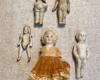 Old porcelain bisque dolls, two with jointed arms. Dollhouse doll with dress has no arms or legs, doll on far right has one foot chipped. All others are good and very old. (Lot of 5) $24