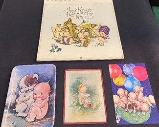 Kewpie items-"1975" Calendar, kewpie dish, old framed Kewpie postcard, Kewpie postcard "1990's" unused. $12