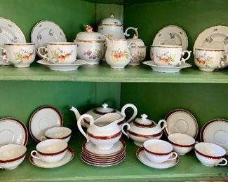 Corner Cabinet interior with two sets of china.  Bottom shelf china: Czechoslovakia porcelain tea set (six cups and six saucers, six dessert plates, one sugar bowl with handles, one creamer and one teapot (teapot handle damaged and repaired).