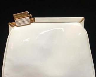 This Judith Leiber White Patent Leather Clutch is available for purchase at:       https://scavengersparadiseestatesales.com