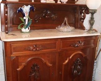 50 - Walnut Victorian sideboard with white marble top, carved backsplash and pulls, 99 in. T, 54 in. W, 20 in. D.