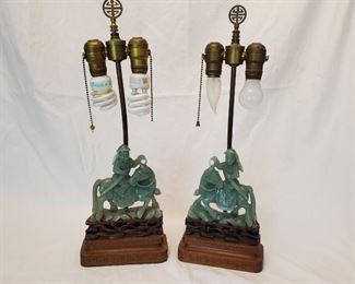 $195 - Pair of Vintage Carved Stone Lamps - Pair of Asian inspired lamps with riders on horseback made of carved green stone on carved wood bases. One lamp has a light that does not have a pullable chain; the other lights were tested and all are working. Each lamp stands 20.5" tall; the stone figures are 6.25" tall by themselves. Sold without shades.