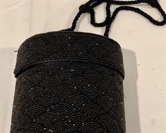 $30; Black sequin evening bag; oval box shape with lid and rope strap.