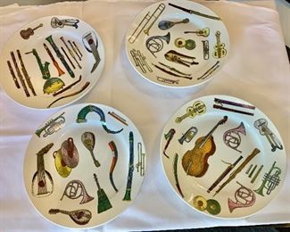 $600 - Suite of four handpainted Fornasetti "instrument" plates; 9 in. (diameter)