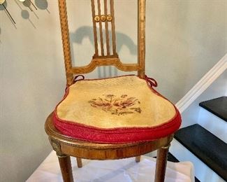 $150 - Vintage chair with inlaid wood back, cane seat,  needlepoint seat cover and casters; 35 in. (H) x 18 in. (seat height from floor) x 16 in. (W) x 18 in. (depth)