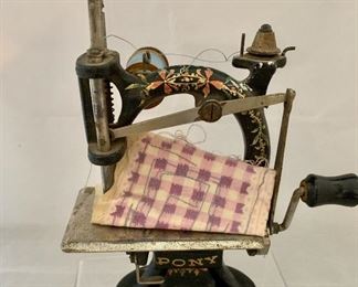 $50; Antique cast iron/mixed metal miniature sewing machine; 8 in. (H) x 6 in. (L) x 3 in. (depth)