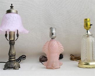 $60 Left: Boudoir lamp, brass finish, pink glass shade with fluted edge.  H: 14" | diameter: 7"
$40 Center: Boudoir lamp, pink pressed glass base, no shade.  W: 5" | H: 8" | D: 4"
$40 Right: Boudoir lamp, gold-finished metal and clear pressed glass, no shade.  H: 10" | diameter: 4.5" [Furniture]