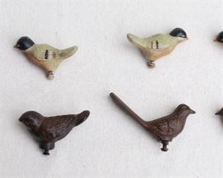 $25 each set of 2. Lower left: Set of 2 dark cast metal birds w/ short tails, screw on bottom to affix to shelf.  L: 3" | W: 1.5" | H: 1.5"
Lower right: Set of 2 dark cast metal birds w/ long tails, screw on bottom to affix to shelf.  L: 4" | W: 1" | H: 2.5"
Upper: Set of 4 painted cast metal bird w/ short tails, screw on bottom to affix to shelf.  L: 3" | W: 1" | H: 1.5" [Bin 37] 