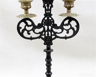 $75 3-branch black cast metal candelabra, brass candle holders.  W: 7" | H: 14.5" | D: 4" [Props] 