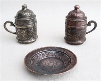 $40 Turkish coffee set of 2 cast metal cups w/ white ceramic inserts and matching lids (one silvertone, one coppertone), plus matching coppertone plate.  W: 3.5" | H: 4" | D: 2.5" | plate diameter: 4" [Bin 26] 