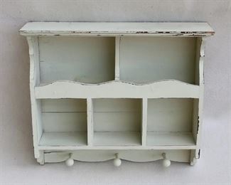 $30 Distressed hanging shelf.  Wood painted a pale sea foam green, 5 compartments, 3 pegs below, 2 hangers on back.  W: 18.5" | H: 16" | D: 4.5" 