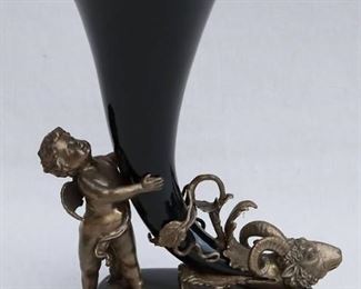 $40 - Dark glazed ceramic cornucopia w/ antiqued gold trim, metal ram's head on small end, held vertical on ceramic stand by metal cherub.  W: 9.5" | H: 13" | D: 6.5"