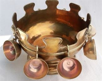 $50 - Brass punch bowl, crenelated rim, with 2 rams head bail handles and 7 brass punch cups with handles.  Punch bowl H: 7.5" | diameter: 10.5"; punch cups diameter: 3" [Bin 8B] 