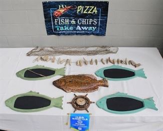 $60 - LOT of nautical set dressing: hanging green wooden fish w/ chalk board bodies (4); hanging painted wooden fish (1); ship's wheel battery clock (1); nets (5); strings of driftwood floats (2); Dublin Rotary Club banner (1); plastic banner "Pizza Fish & Chips Take Away" (1)  [Bin 6] 