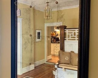 Modern mirror with black frame and distressed silvering. 