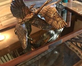 Brass ducks in flight