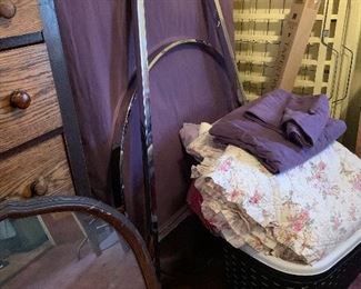 Clothing rack, antique dresser mirror, linens.