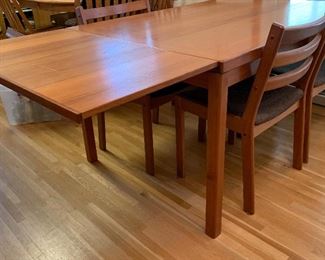 Very nice mid century dining table and four chairs. Table has hidden expandable leaves. 