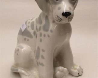 A porcelain figure of a puppy dog with gray spots.  Ink stamped on base - Made in Russia.  6.5" tall