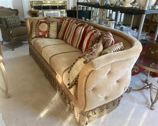 Gold velvet barrel sofa with lots of pillows
