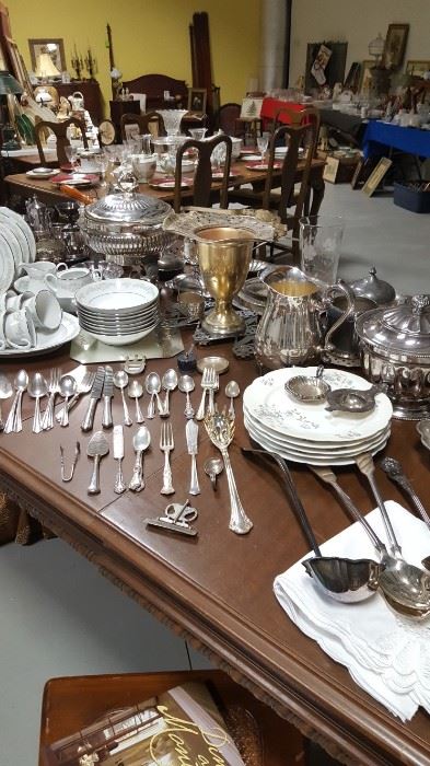 Lots of silver plate and china on antique tables