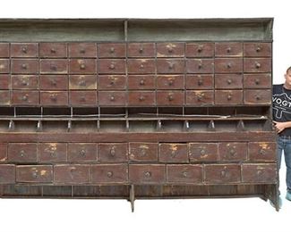 Monumental rustic general store apothecary cabinet, very primitive, 58-drawers, open shelving.
90"h x 138.5"w x 14"d.
Condition: Very unstable, will need to be braced to a wall, previously cut through center