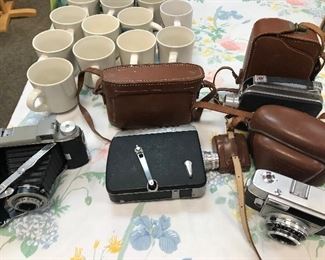 Cameras- Kodak Tourist, last in the line of American-made folding roll cameras Tourist series introduced in 1948, production discontinued in July 1958; and an AGFA Optima II Prontormator 1960s, 35mm viewfinder that's made in Germany; and a Cine-Kodak Magazine 8, made in the USA 1946; and a Cine-Kodak Royal Magazine 1936, all with cases (R) LW.