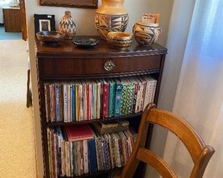Bookcase $85.00 with children's books.  Caned seat chair, Native pottery