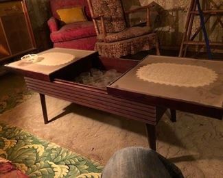 beautiful mid century modern bar table that opens up to different size alcohol glasses 