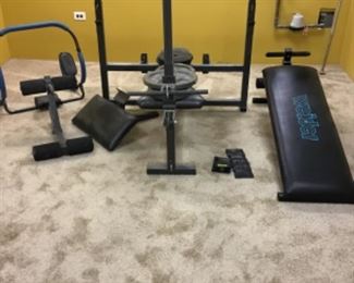 Weiider workout bench, barbells, bars and other weigh lifting items.