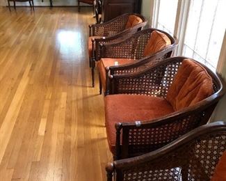 Several club chairs with orange cushions