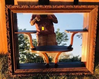Vintage estate mirror with decorative carved wooden shelves, measures approximately 33 inches tall and 27 inches wide.